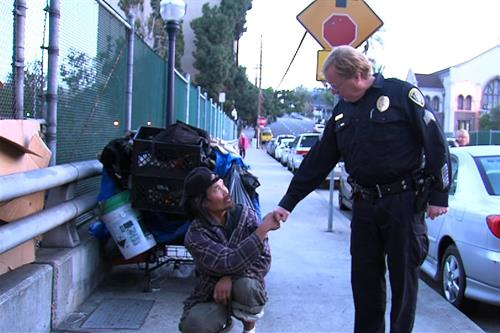 A police officer interacting with a man on the street