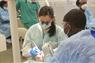 Students cleaning patient's teeth