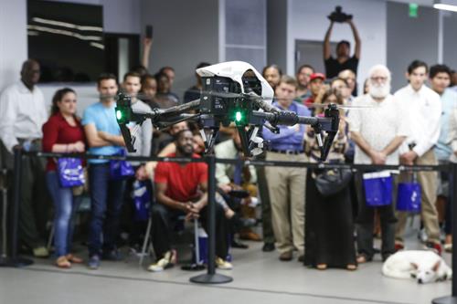 Students watching a drone fly in the classroom;