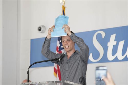 Miami Dade College alumnus Felipe Matos holds up his paper work for deferred action.