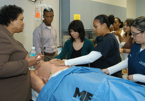 Nursing students receive instruction on a human patient simulator