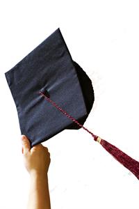 Hand holding up graduation cap