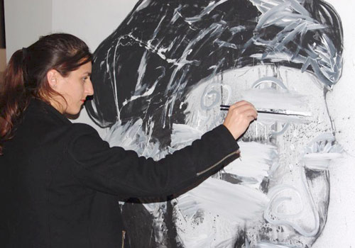 A viewer paints on one of González-Trejo's artworks.