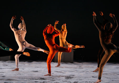 Dancers in brightly colored outfits perform Shaker on stage