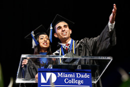 MDC graduate wearing the cap and gown speaking at the commencement ceremony