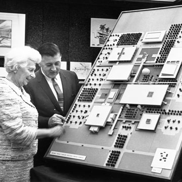 The 60s: Two people looking at a college building model