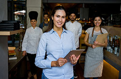 restaurant manager with employees in the background