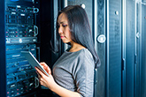 Information Technology - a female student working in front of network servers.