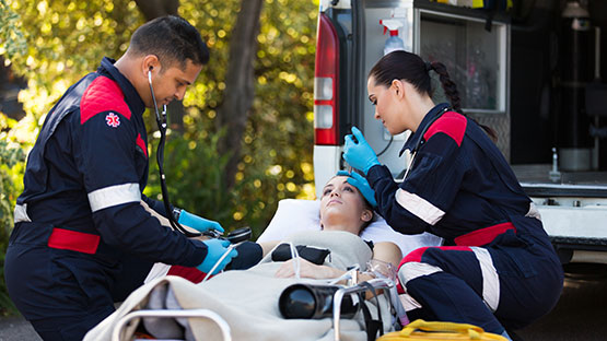 Emergency Medical Technicians examining patient