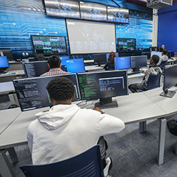 Cybersecurity classroom with computers desks and students sitting