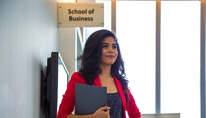 A student standing by the Business Department - Miguel B. Fernandez School of Global Business, Trade and Transportation