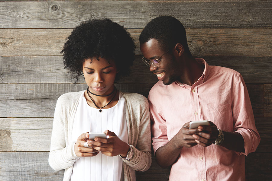 Photo of a African American couple using budgeting apps on their smartphones