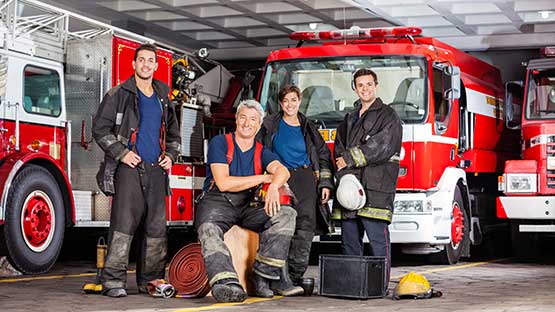 Group of fire fighters sitting in front of fire truck