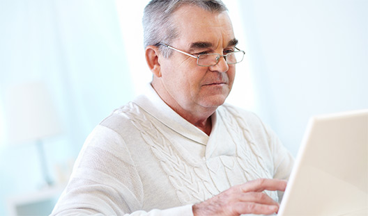 Photo of a male age 55+, using a computer