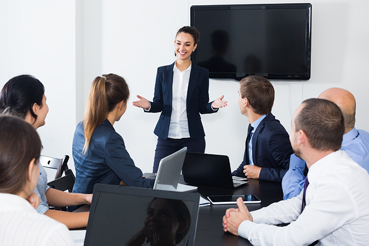 Young woman giving a presentation to fellow coworkers