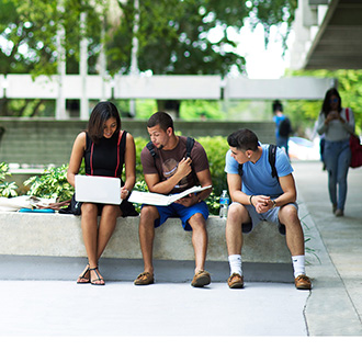 Group of students sitting outside enjoying the MDC campus