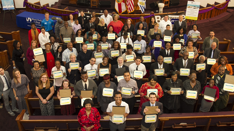 Program attendees holding up a certificate of completion
