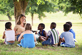 teacher with students underneath a tree