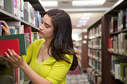 Student placing library books on shelf