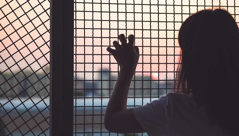 girl trapped behind a fence