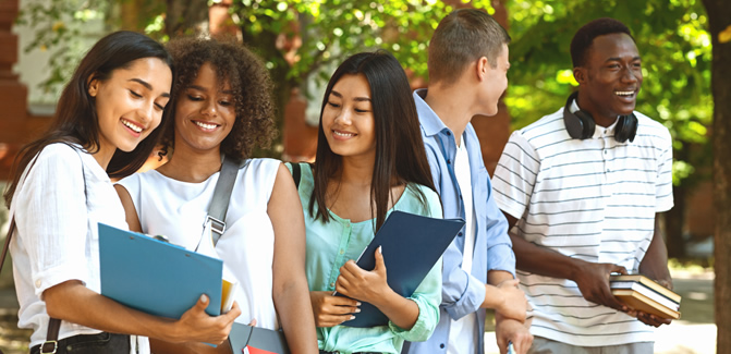 Group of college students laugh and hang out after class outside