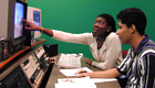 A teacher instructs a student in an audio-visual lab