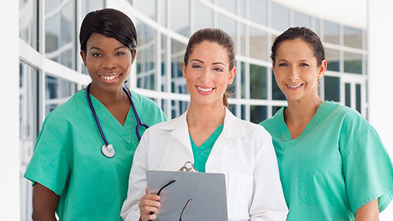 Three licensed practical nurses wearing lab coats