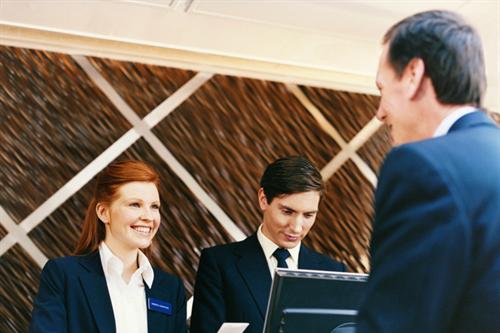 Hotel receptionist welcomes guest
