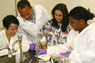 Rosa Castro, an assistant professor of clinical laboratory technology (multi-colored scrubs) works with biologists from Mozambique.