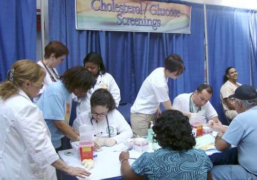 Students in uniforms and scrubs with patients