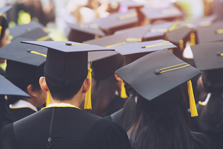 Graduates stand during graduation