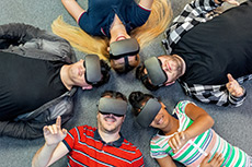 A group of diverse students laying on floor wearing VR sets