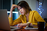 Female student in front of laptop with worried look