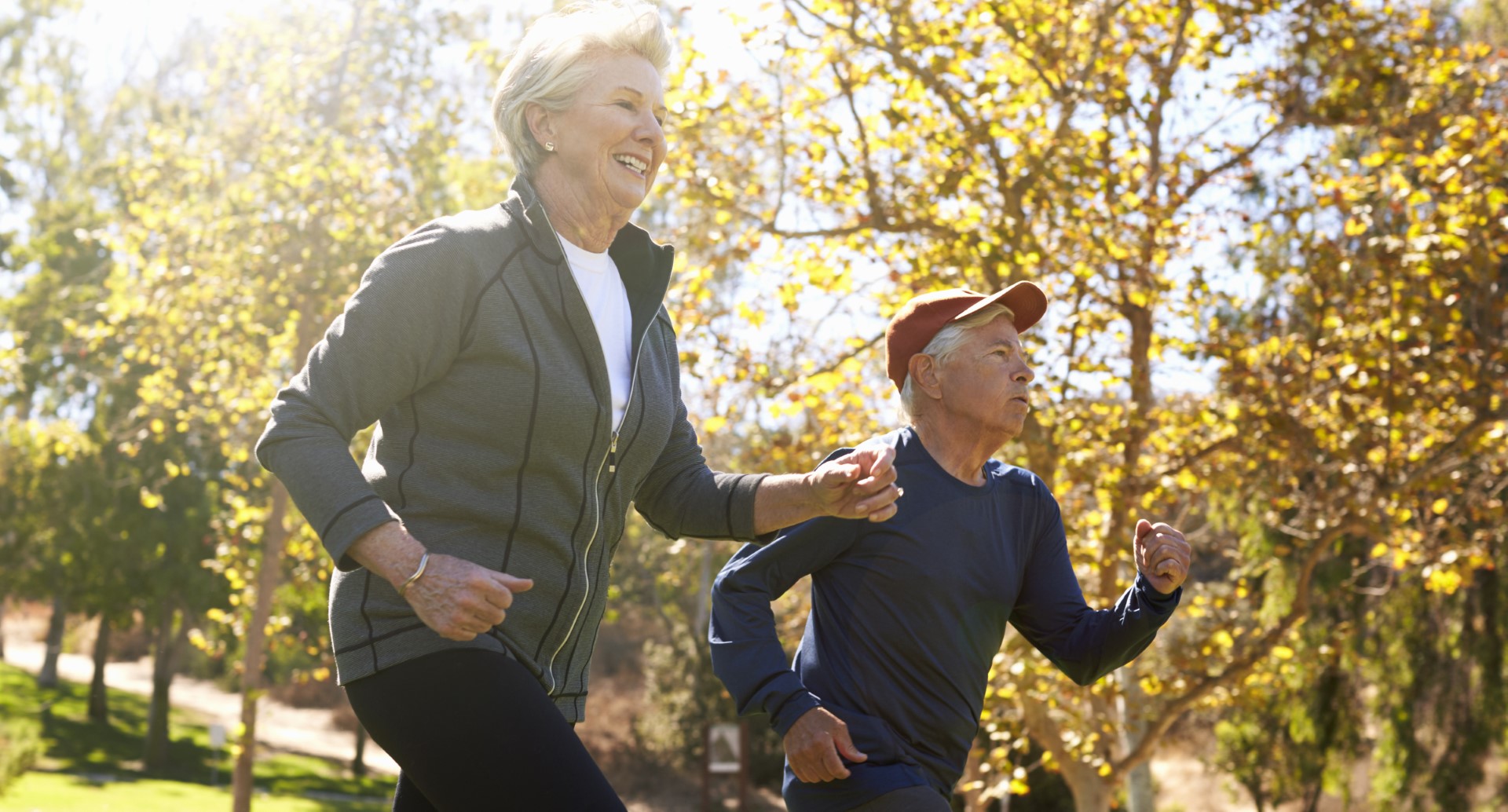 A elderly couple exercises outside