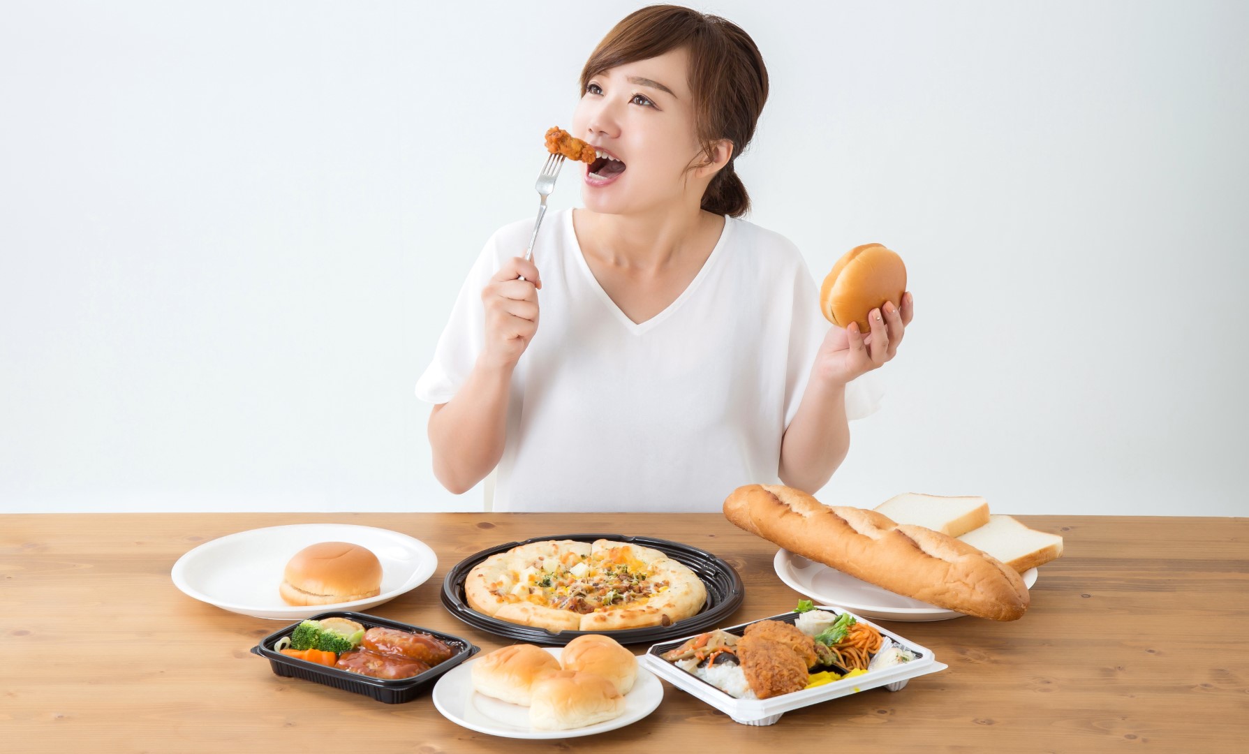 An Asian woman eating food at a table