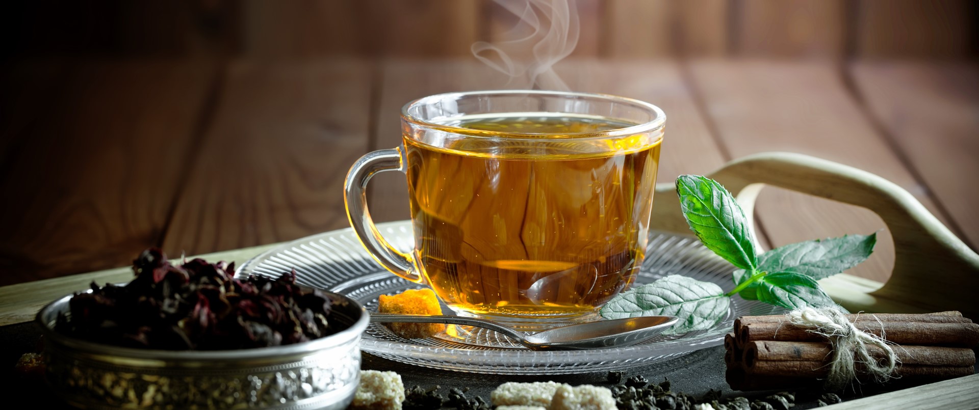 A cup of steaming tea decoratively placed on a platter arrangement  