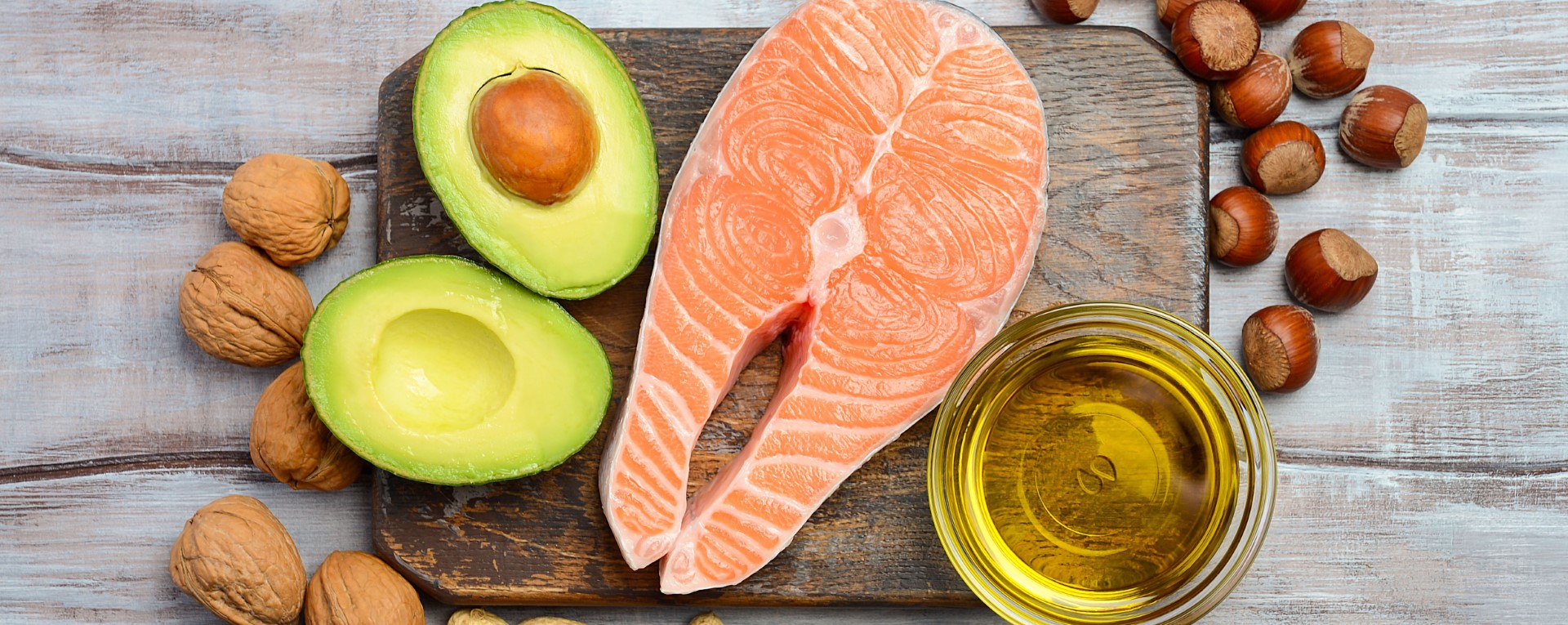 Healthy assortment of healthy protein such as nuts, avocados, olive oil and wild salmon 