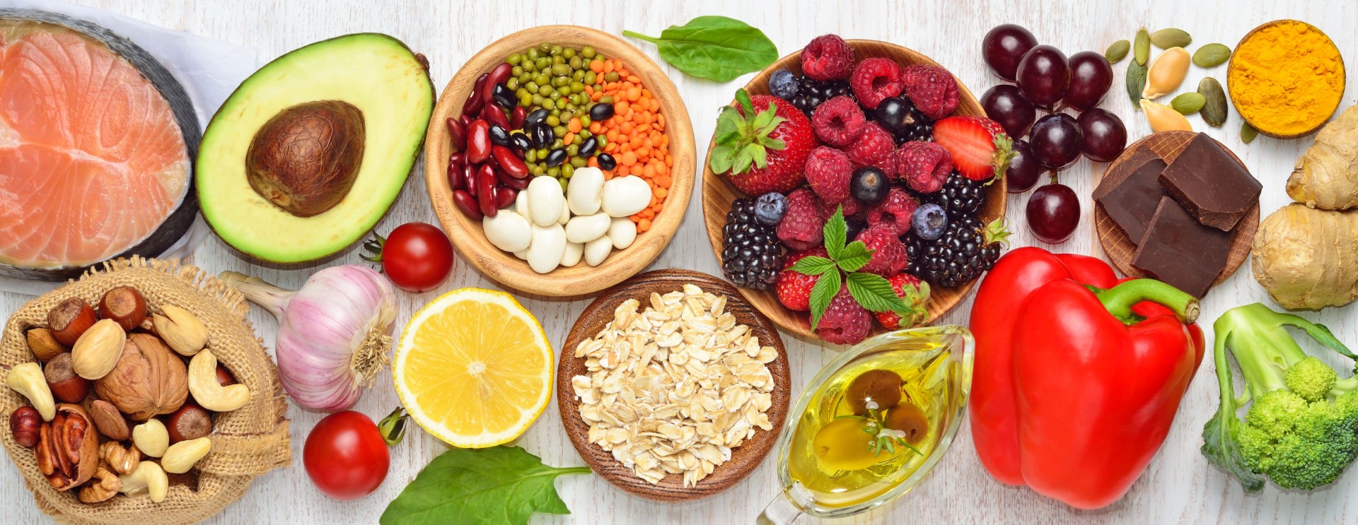 Wide assortment of healthy fruits, vegetables, oils, meats and protein laid out on a table