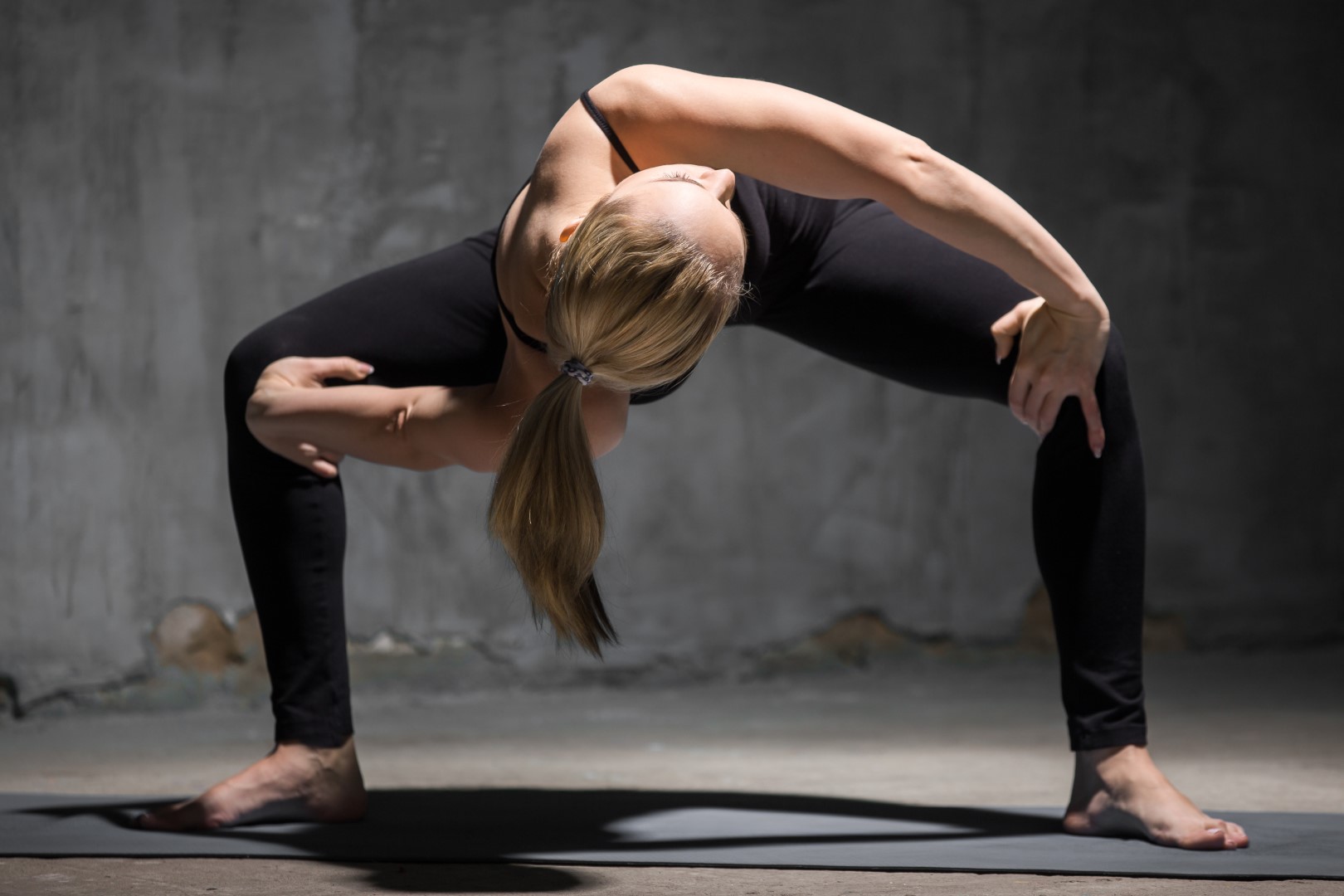 A woman demonstrates the yoga sumo squat twist