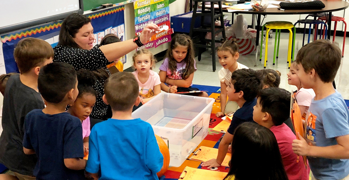 Teacher demonstrating educational toys to students