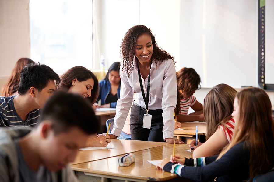 Educator speaking with students at a table