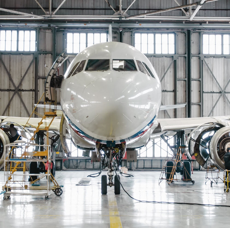Front view of an airplane in a hangar undergoing maintenance.