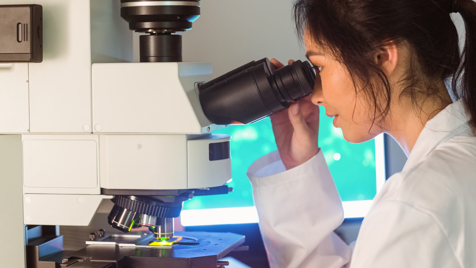 A female student practices using a power electron microscope