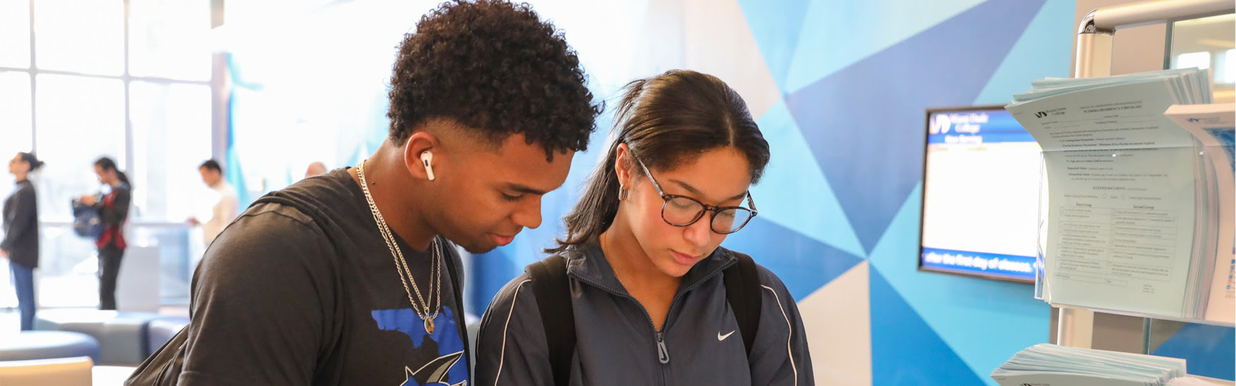 Two students reviewing documents indoors.