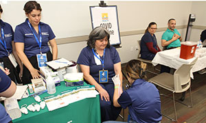 Nurse doing a skin cancer screening to a woman at the Community Health Fair