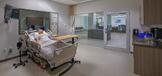 A room with a state of the art simulation dummy on a hospital bed