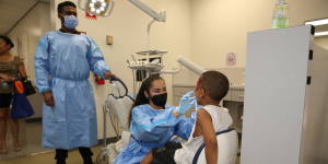 Dental student working teaching a child about dental hygiene