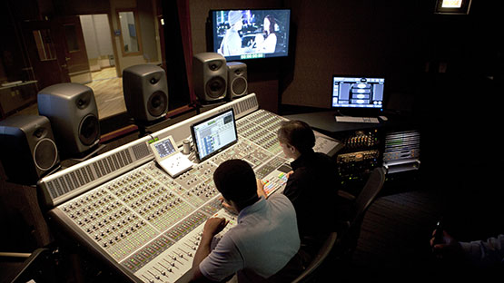 Students in a music studio working with a production console