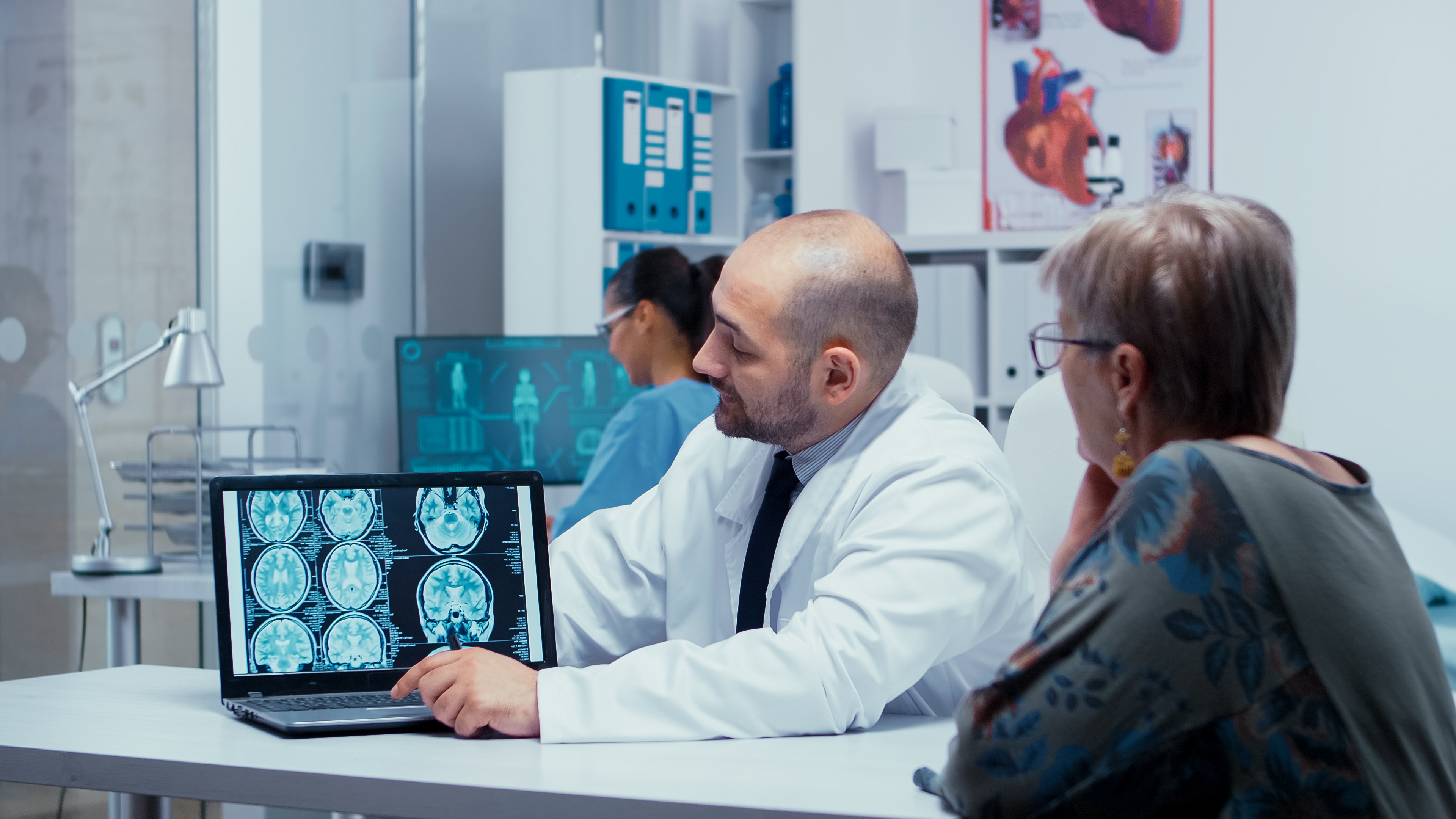Neuroscience tech checking a senior's brain scan