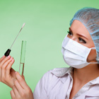 Image of lab nurse looking at susbstance inside test tube.